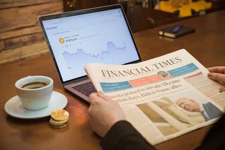 Comparing recent news coverage with an older article on a laptop.
